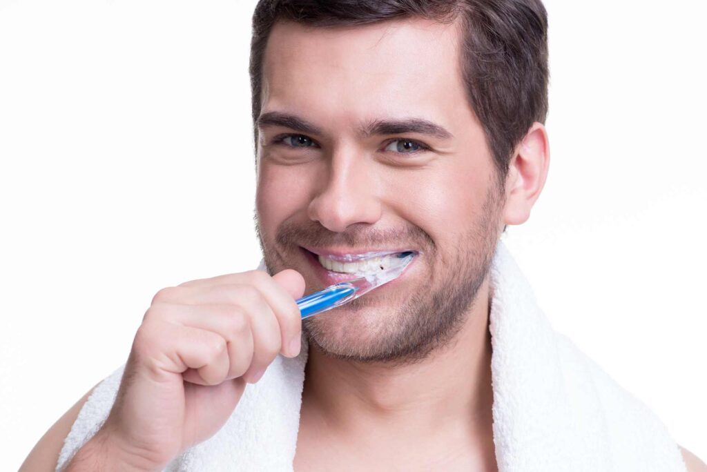 05 Close up of a young man brushing his teeth at a 45 degree angle, the correct angle to avoid gum recession.