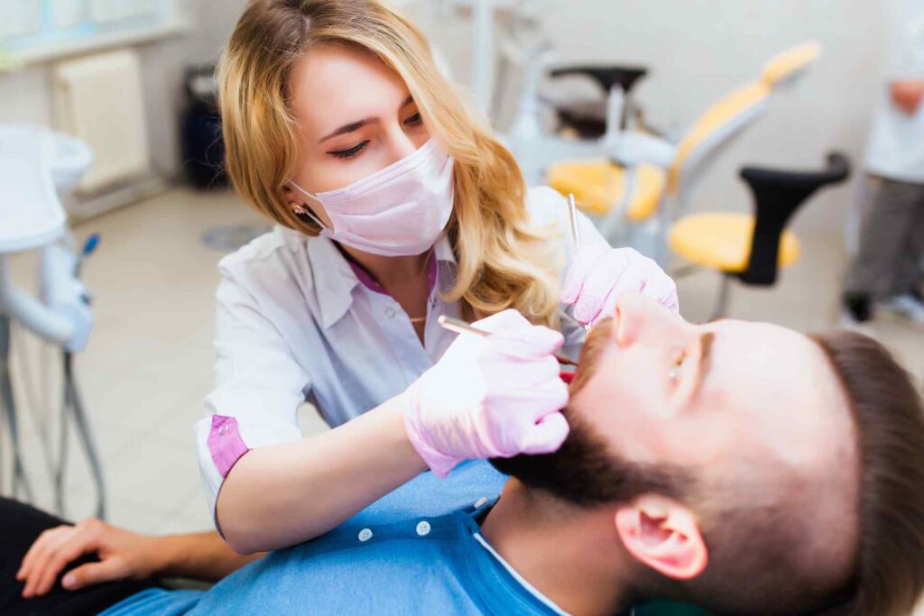 07 Dentist performing treatment on a man in the clinic