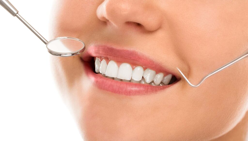 08 A smiling woman with dentist tools near her mouth on a white background_Porcelain veneers vs. Bonding