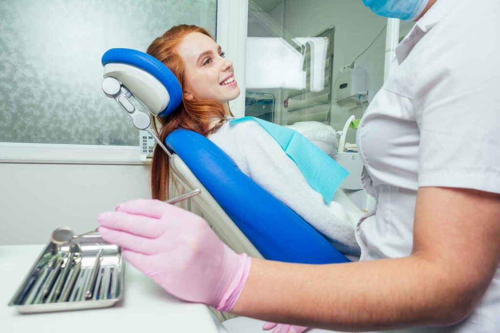 A patient smiles at her dentist during a treatment at the smile design Miami clinic.