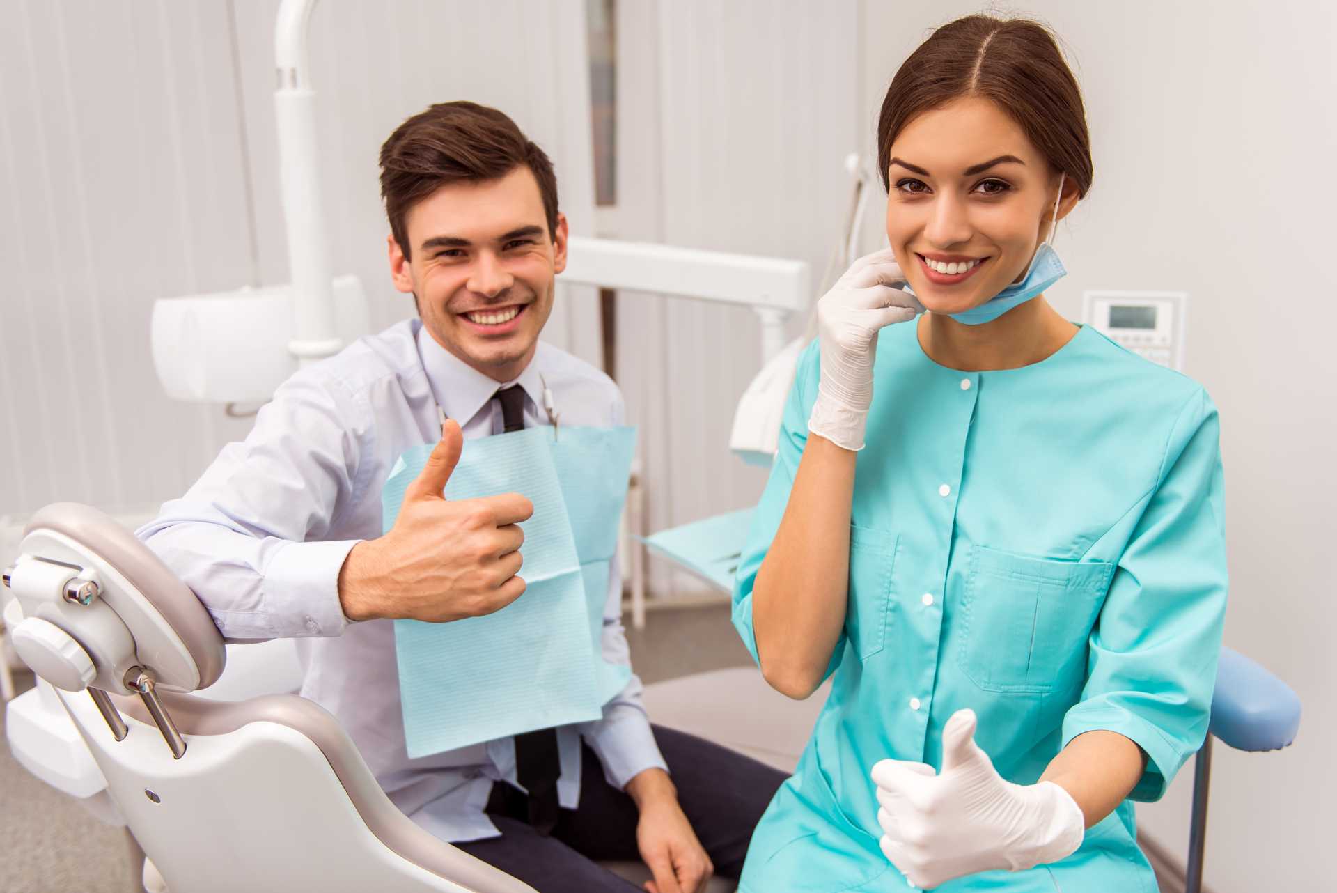 01 A dentist and her patient in the clinic making the thumbs up gesture in the direction of OK_Recovery of dental implants,