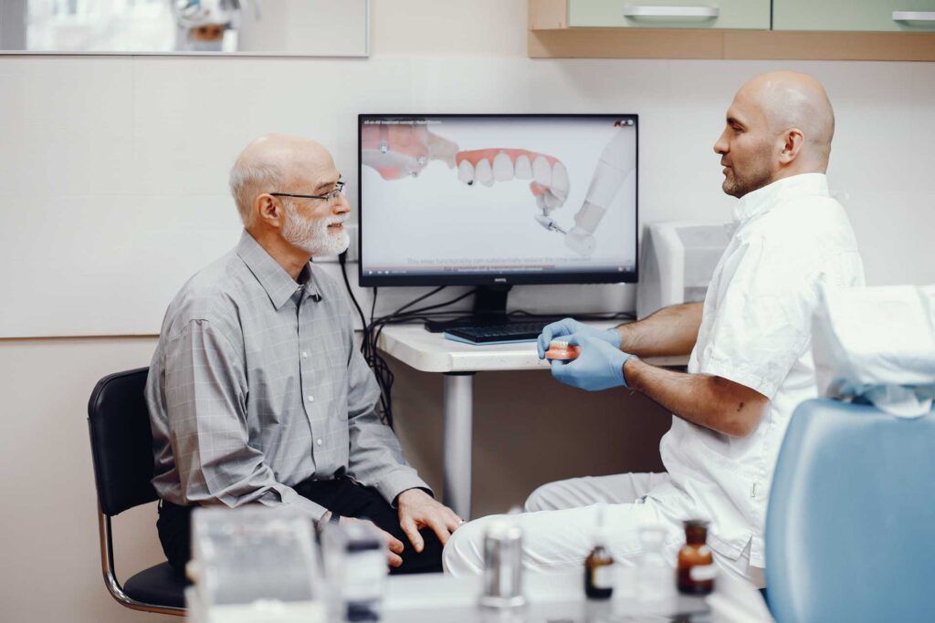 04 Dental specialist explaining to a mature man the implant procedure_Dental implants recovery, Dental Implants in Miami