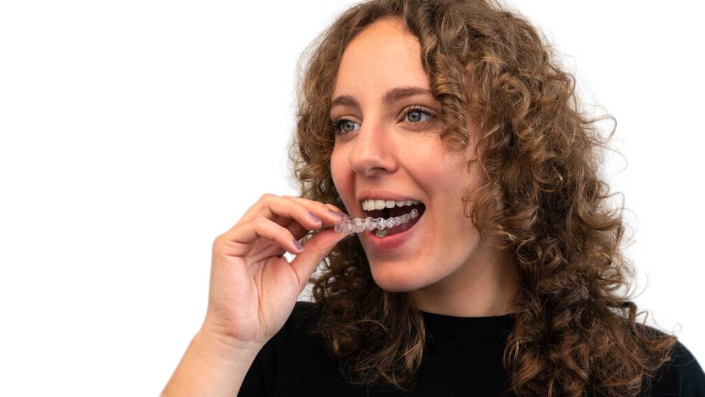 09 An adult woman putting on a splint for teeth, isolated on white background_Recovery of dental implants, Dental Implants i
