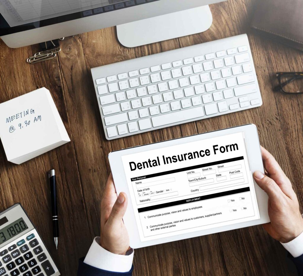 10 A man in a suit filling out a dental insurance policy_Dental insurance in the U.S. that covers implants