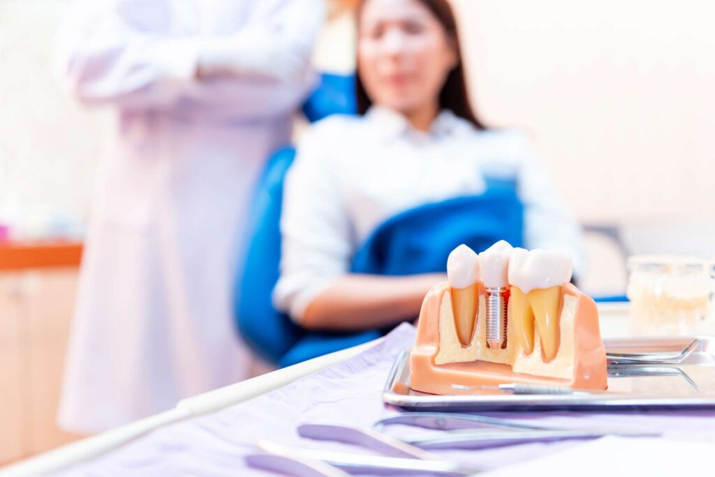 10 Close-up of mock-up of denture with dental implant and patient and dentist out of focus in the background_What is the risk of dent