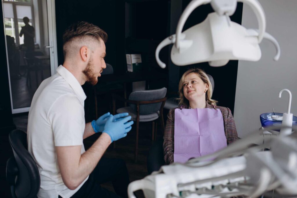 13 A dentist explaining treatment to a patient at the clinic_Dental insurance in the U.S.A. covering implants