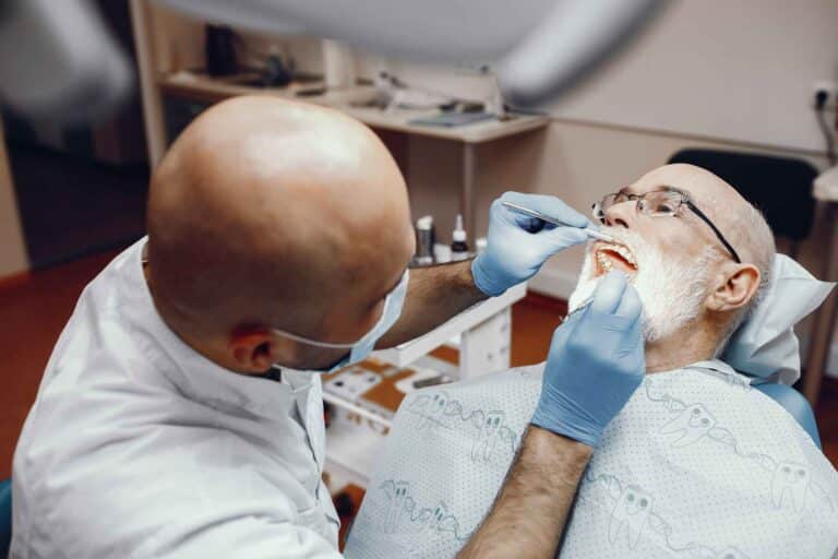 01 Older man receiving dental treatment_Problems with dental implants symptoms