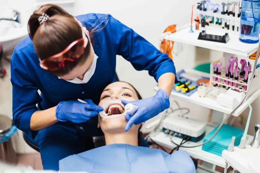 Dentist applying gel to whiten patient's teeth_tooth