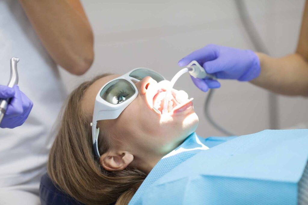 A woman receiving laser treatment at a dental clinic