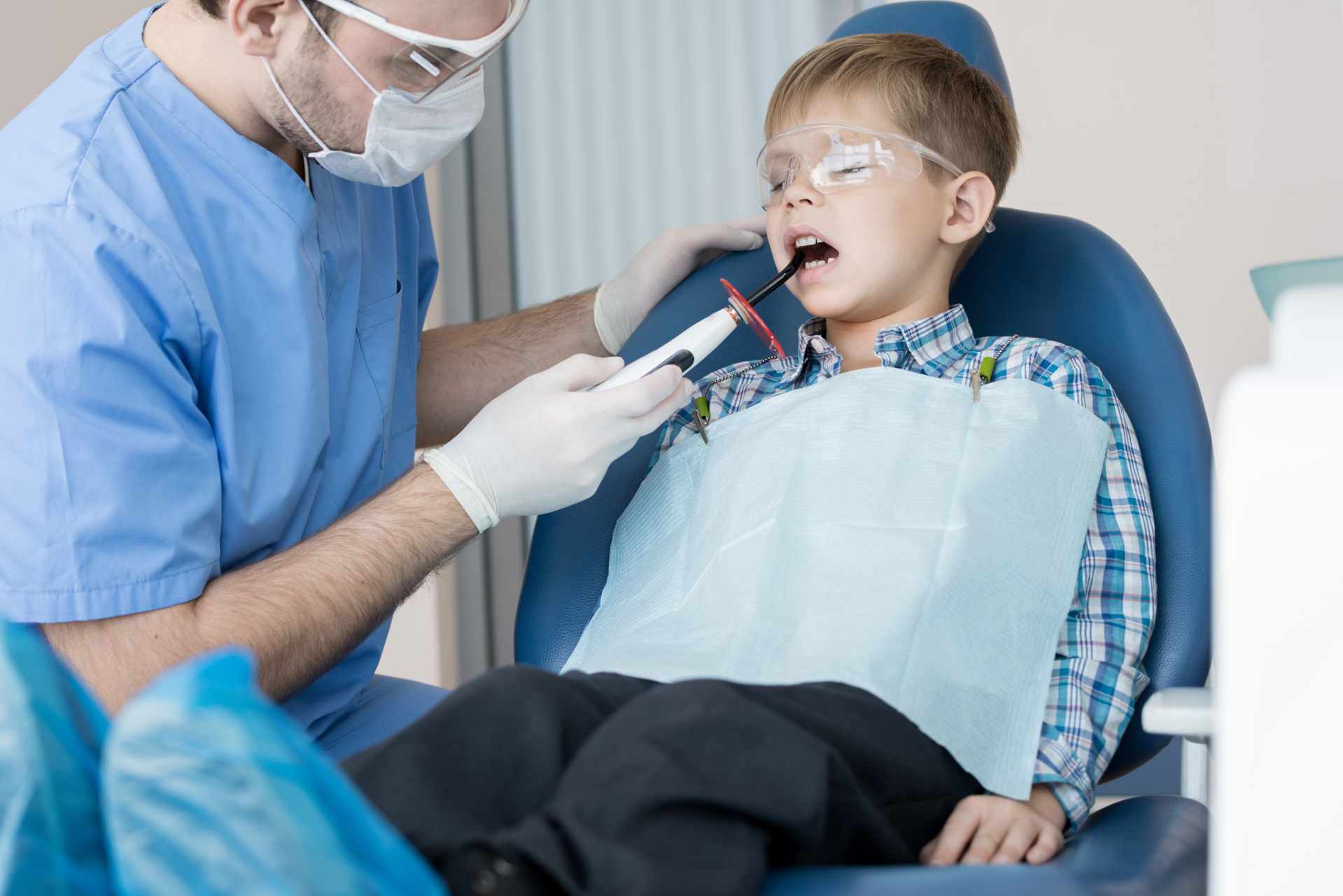 Child patient receiving laser dentistry treatment in a clinic